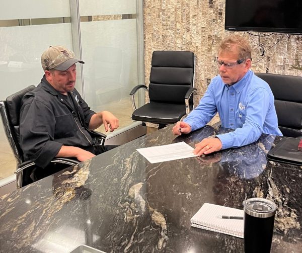 Nathan's trainer Chad and Career Ready Monitor Richard Janik go over Nathan's Technical Objectives in the conference room at Cavalier Tool.