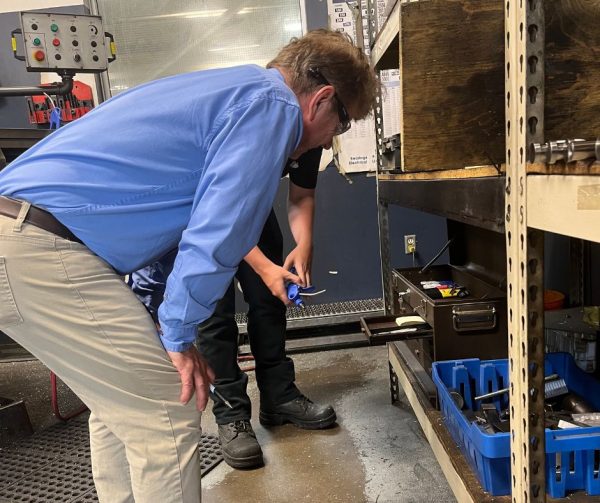 Career Ready Monitor Richard Janik inspects the tool shelf in the detail room at Cavalier Tool and Manufacturing.