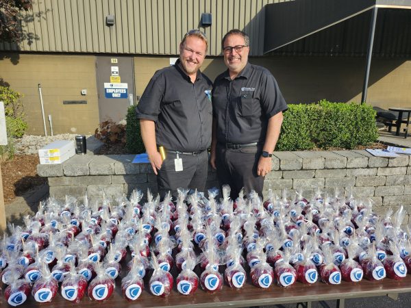 Two Cavalier Tool Program Managers stand in front of a table with Candy Apples on it. It's Manufacturing Day