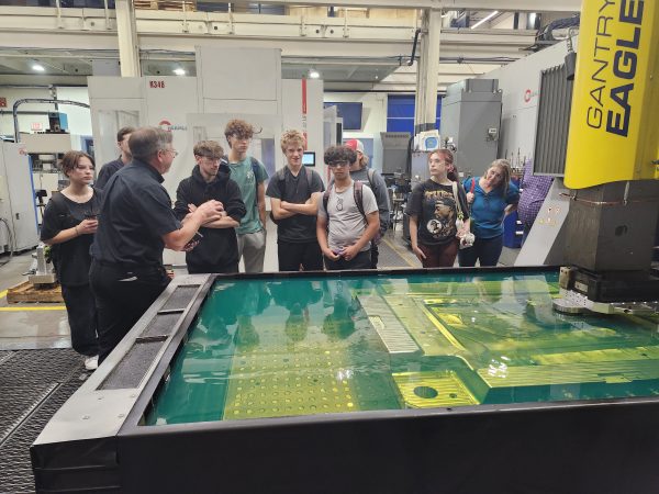 Plant Manager Larry Caron explaining EDM Technology to students on Manufacturing Day